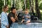 Mom, dad and little son in a convertible car. Summer family road trip to nature