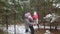 Mom and dad play and throw the child in the winter forest park. Portrait of a happy family in the fresh air, walking in