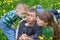 Mom dad and son together blowing on a dandelion in a meadow