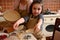 Mom and daughter in aprons, cooking together, showing rolled dough in the molds while making homemade tartlets and tarte