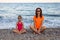 Mom and daughter on the beach, family vacation.Mom and daughter meditate on the beach