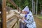 Mom and daughter caress the face of a foal at the petting zoo.