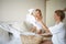 Mom and daughter disassemble a wicker basket of laundry