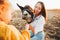 Mom and daughter feed and pet a donkey in a contact zoo.