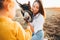 Mom and daughter feed and pet a donkey in a contact zoo.