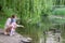 Mom and daughter feeding duck in a park on the lake