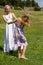 Mom and daughter in field having fun and dancing.