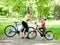 Mom and daughter give high five while cycling in the park