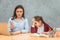 Mom and daughter on a gray background. During this, Mom found a solution to the problem on the laptop, showing her