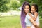 Mom and daughter have fun in the park, a happy parent with a child in her arms plays in nature on a summer day, family and