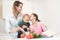 Mom and daughter have fun while preparing a salad. They are in a bright kitchen.