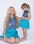 Mom and daughter in identical dresses are sitting on a white background, blondes.