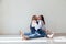 Mom and daughter in jeans sit together cuddling