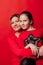 Mom and daughter lovingly cuddle on a red background