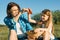 Mom and daughter in nature, summer country holidays, mother and child sitting on the grass eating strawberries