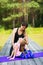 Mom and daughter perform gymnastic exercises on a sunny summer morning in the park