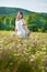 Mom and daughter on a picnic in the chamomile field. Two beautiful blondes in chamomile field on a background of horse