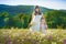 Mom and daughter on a picnic in the chamomile field. Two beautiful blondes in chamomile field on a background of horse