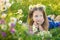 Mom and daughter on a picnic in the chamomile field. Two beautiful blondes in chamomile field on a background of horse