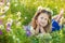 Mom and daughter on a picnic in the chamomile field. Two beautiful blondes in chamomile field on a background of horse