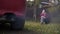 Mom and daughter are playing in a meadow near which a smoking car