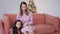 mom and daughter in purple dresses sitting on couch at home on Christmas day