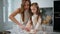 Mom daughter putting dough to baking form indoors close up. Girl helping parent