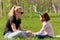 Mom and daughter rest on the green grass