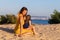 Mom and daughter rest on the sand dunes by the sea