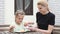 Mom and daughter seven years in the courtyard sitting at table sypyat posypku on Easter cupcake