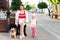 Mom and daughter sit on a bench in the city with a dog breed French Bulldog