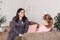 Mom and daughter are sitting on the couch and chatting. Girl teenager with emotions tells her mother a story. Daughter shares her