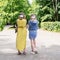 Mom and daughter with a skateboard are walking in the park without observing the mask mode