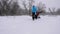 Mom and daughter sledding dad in the winter forest, in snowfall. happy parents and baby play in christmas park. Family