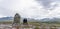 Mom and daughter stands on a mountain top next to a cairn with looking at beautiful mountain view of Rondane national park