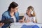 Mom and daughter student learning school lessons together at home