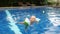 Mom and daughter are swimming in the pool in the resort.