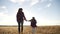 mom and daughter are walking in the park. kid dream happy family concept. mother and little kid holding hands walking