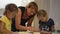 Mom with daughters preparing khachapuri on kitchen table. A child prepares a traditional Georgian dish - khachapuri with cheese fr