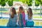 Mom and daughters sit with their backs to the camera and show with their hands a heart symbol. girls and women love