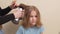 mom dries her daughter's hair with a hair dryer with a comb attachment.