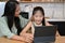 Mom encourages and takes care of her daughter while she`s studying online at home