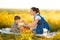 Mom feeds her son on a picnic. Mother and young son in sunny fall day. Happy family and healthy eating concept