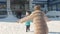 Mom in a fur coat in winter, meets a little daughter after classes in front of the school.