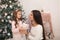 Mom gives her beloved daughter a box with a Christmas present