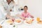 Mom gives her daughter breakfast. They are in the bright kitchen.