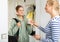 Mom gives pocket money to daughter in the hallway of apartment