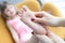 Mom giving foot massage to little girl at home closeup