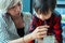 Mom help child drinking water from straw between working.