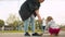 Mom helping baby trying to ride a skate